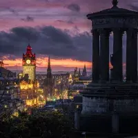 Edinburgh city skyline at dusk, with the monument on Calton Hill in the foreground.